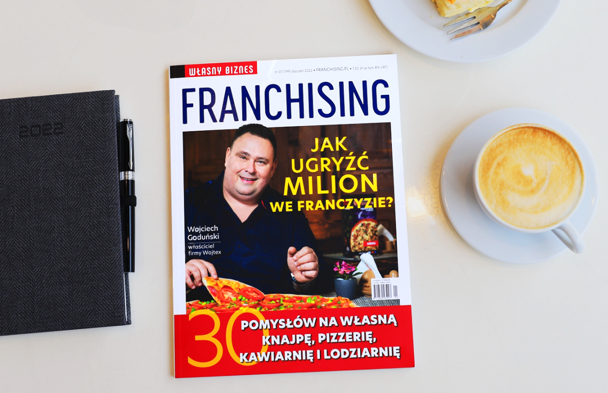 Man on the cover of Franchising magazine, on the right side there is a cup of coffee and on the left side there is a notebook with 2022 date on it.